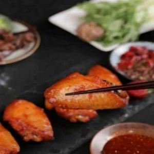 Spicy Chicken Wing Middles in Special Sauce with Vegetable Garnish Flavorful and Colorful Presentation